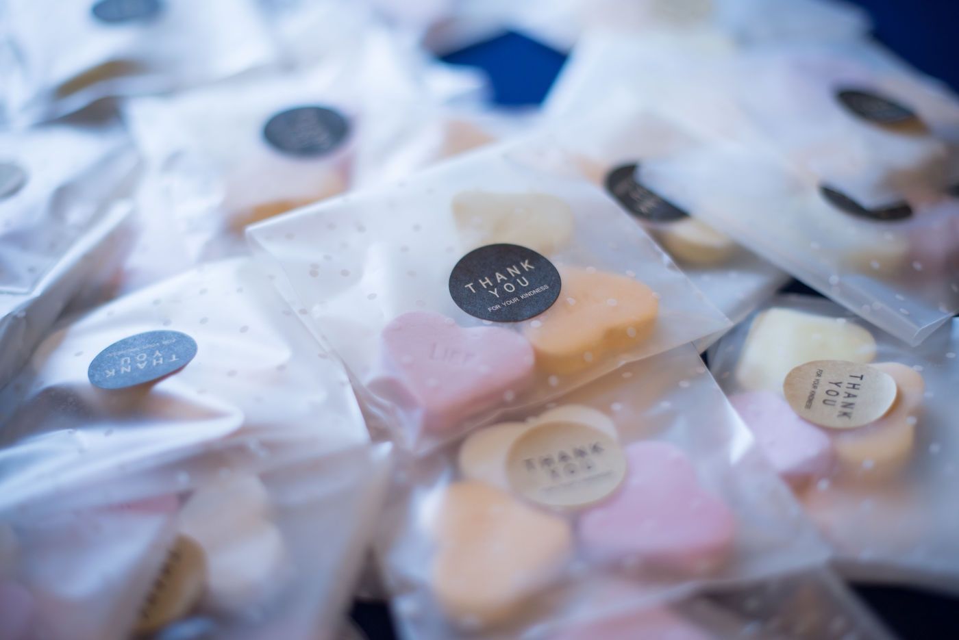 Multiple small, translucent bags each containing pastel heart-shaped candies, sealed with a