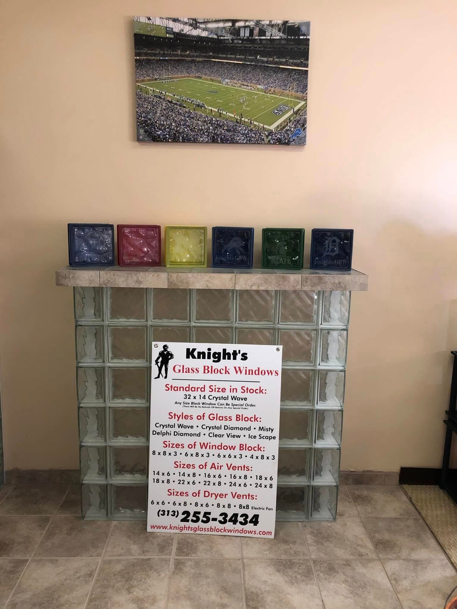 A decorative glass block stand with six colorful containers on top, a promotional sign in front, and stadium art above.