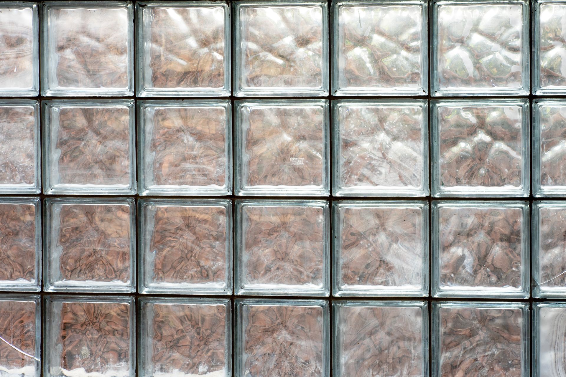 A grid pattern of textured, semi-transparent square glass blocks. A grid pattern of textured, semi-transparent square glass blocks.