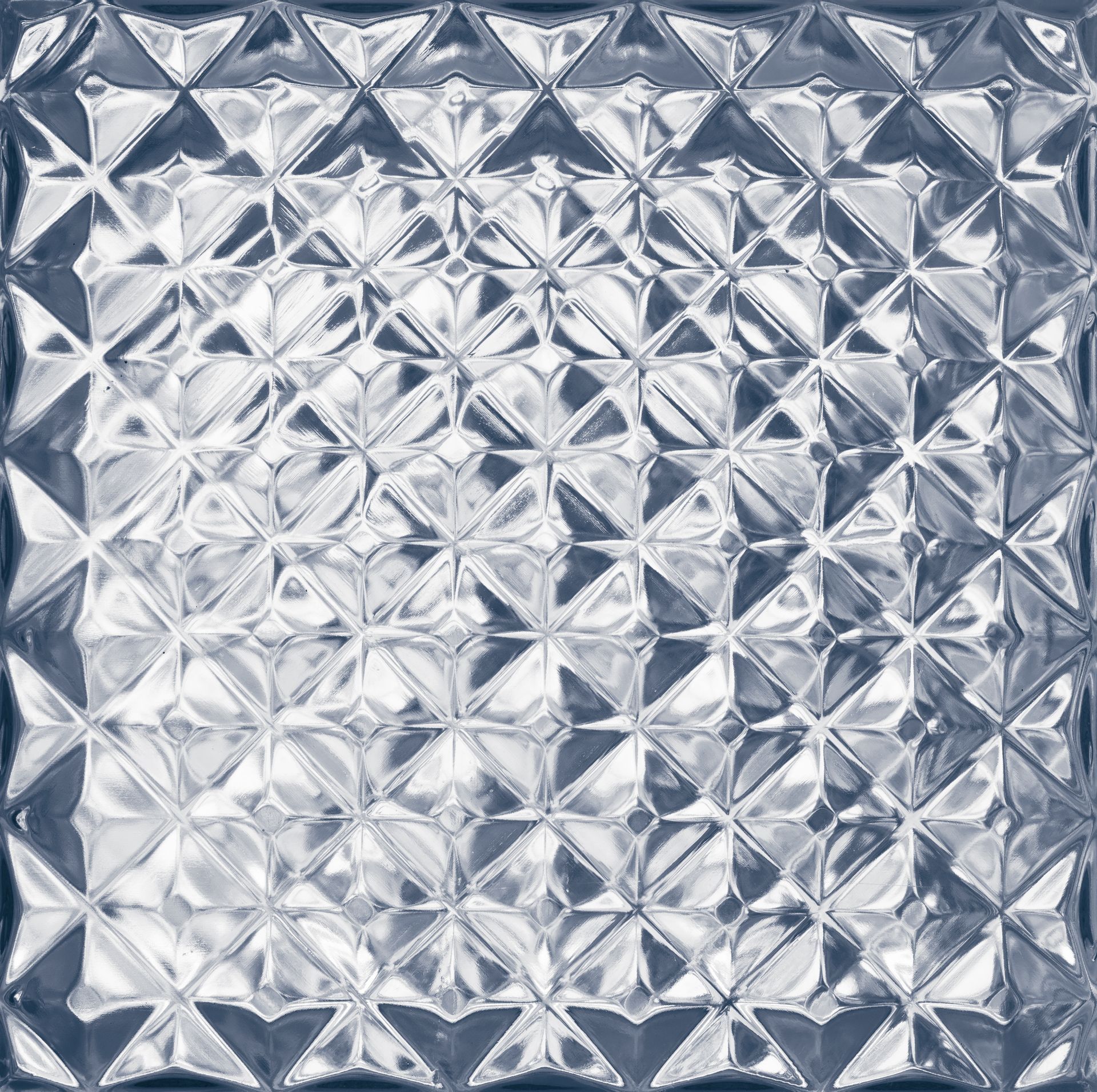 A repeating grid of clear, textured glass squares with a geometric, prism-like surface pattern. A repeating grid of clear, textured glass squares with a geometric, prism-like surface pattern.