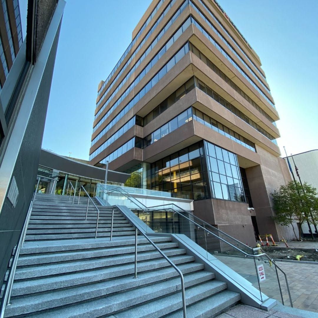 Modern office building with glass facade and wide outdoor stairs leading to the entrance