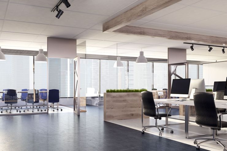 Modern office with desks, chairs, large windows, and a white brick accent wall