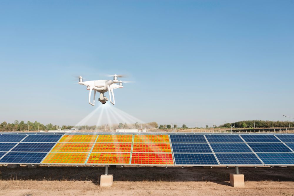 Drone inspecting solar panels, highlighting defects with thermal imaging, outdoors.