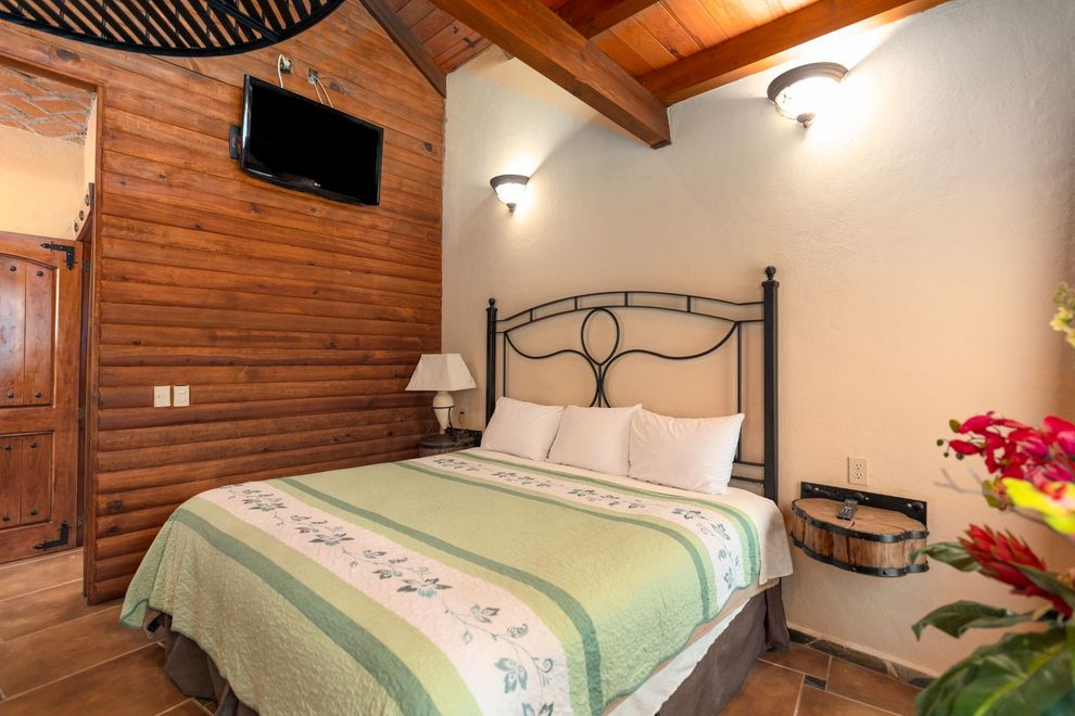 Un dormitorio con una cama king size y un televisor de pantalla plana.