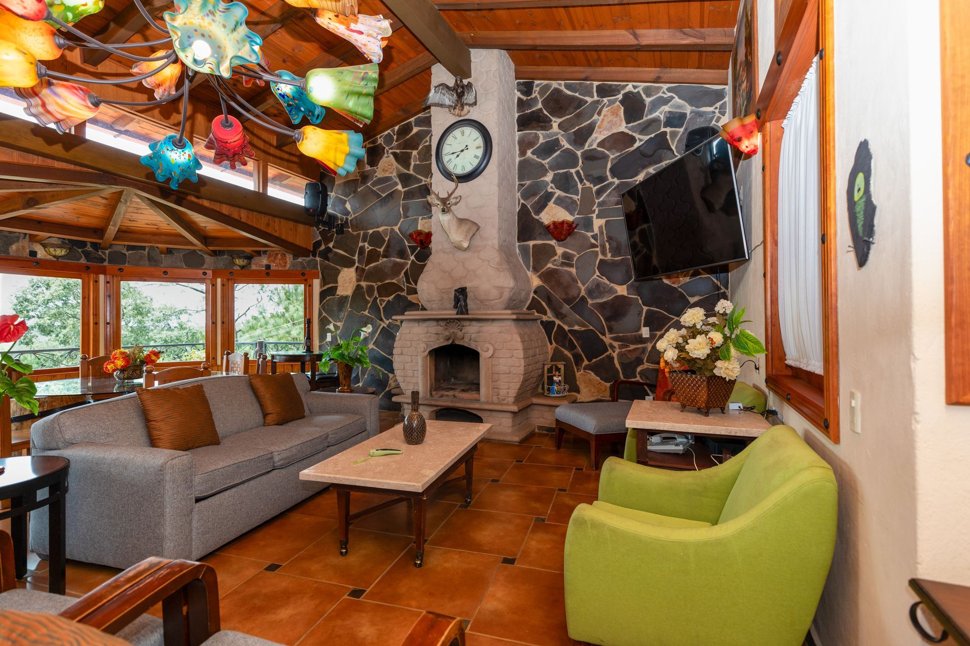 Una sala de estar con sofá, silla, mesa y chimenea.