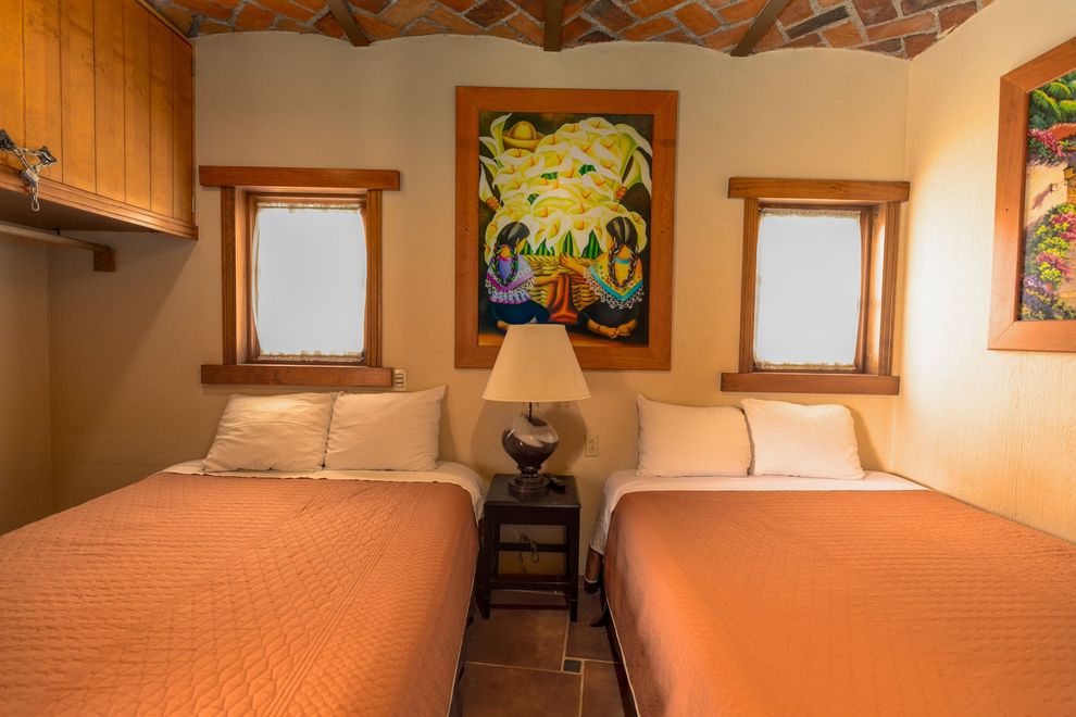 Un dormitorio con dos camas, una lámpara y un cuadro en la pared.