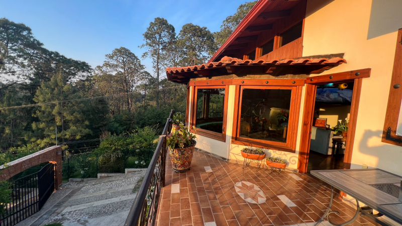 Una casa grande con balcón con vista a un bosque.