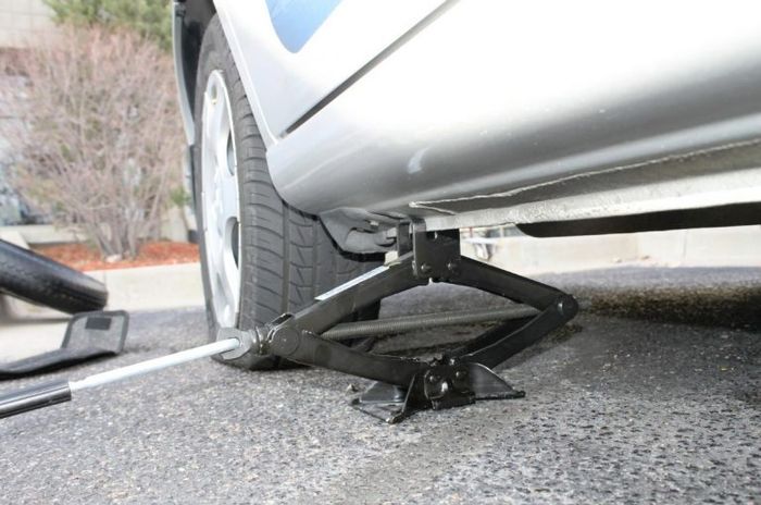 Jacking up a car to fix a flat tire on the roadside