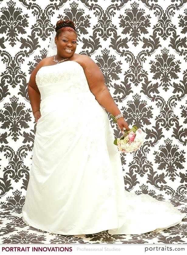 A woman in a wedding dress is posing for a picture