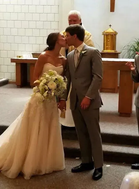 A bride and groom kissing in a church