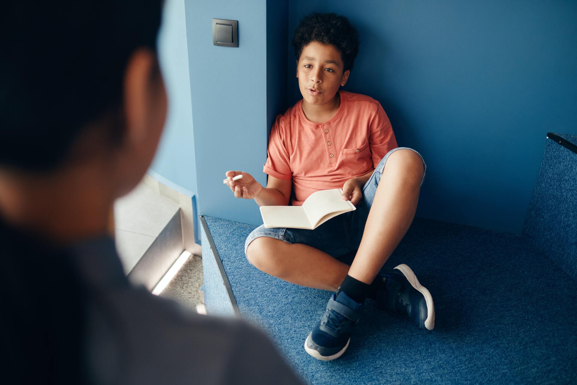 A student with a book questions a person in the foreground