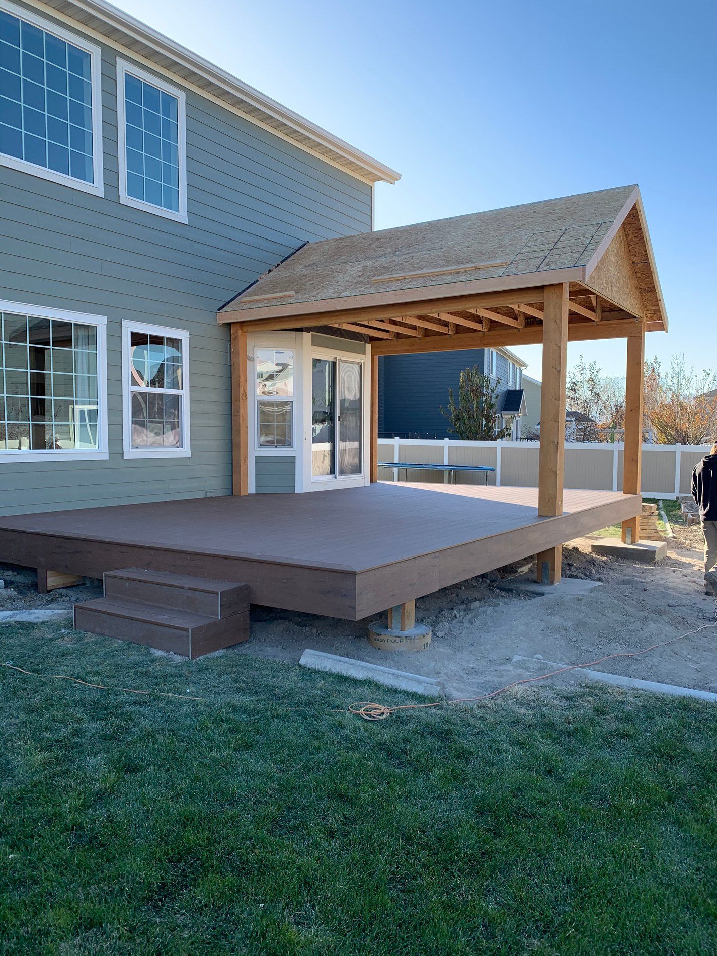 Backyard wooden deck with covered roof attached to a house, under construction
