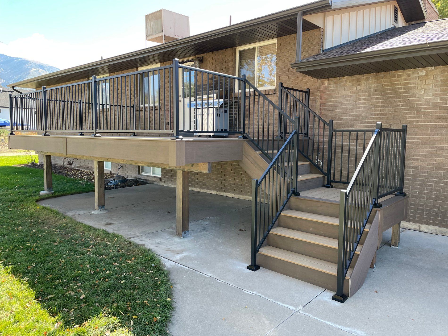 Building entrance ramp and stairs with black railings leading to a brick school-like structure.