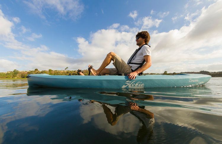 A man is sitting in a kayak on a lake.