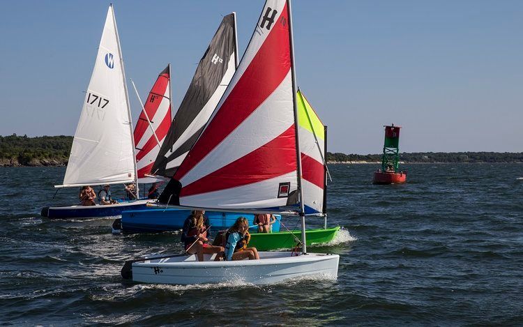 A group of people are sailing boats on a lake.