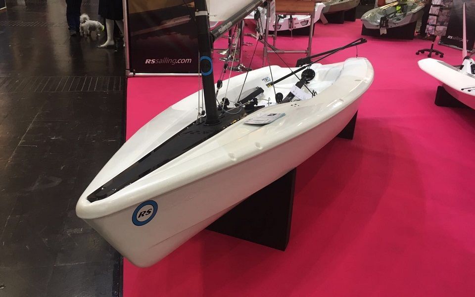 A small white boat is sitting on a pink carpet.