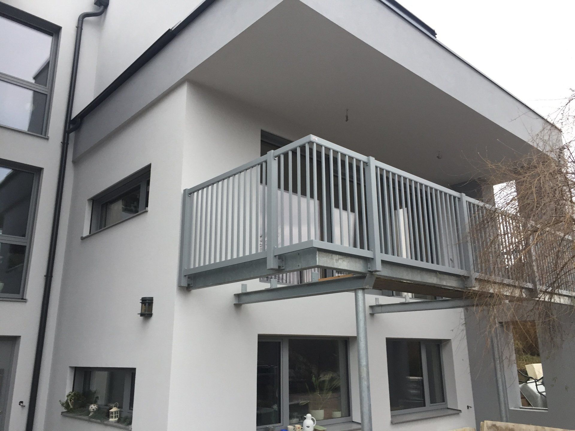 Ein weißes Haus mit einem Balkon an der Seite.