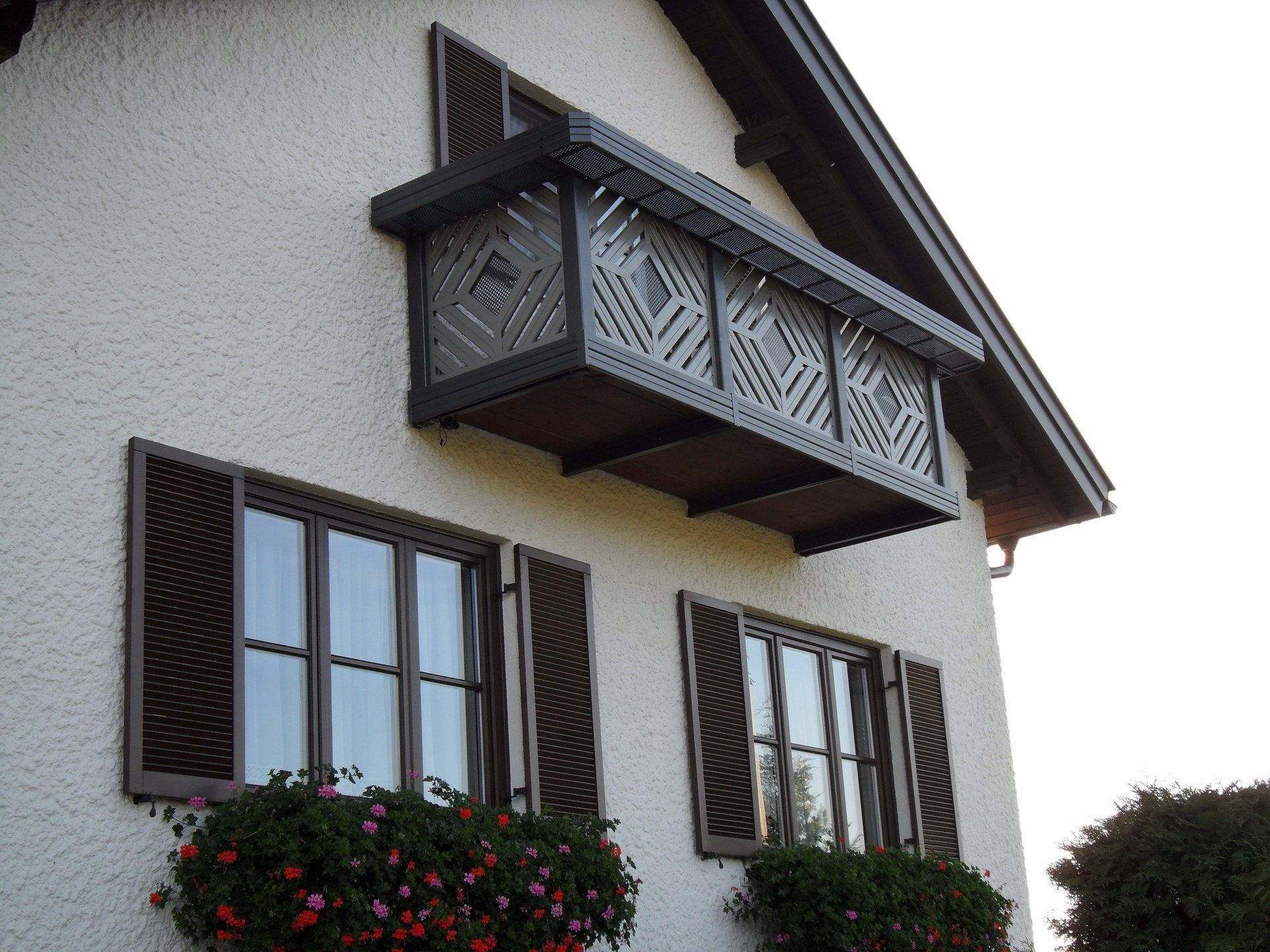 Ein weißes Haus mit Balkon und Fensterläden