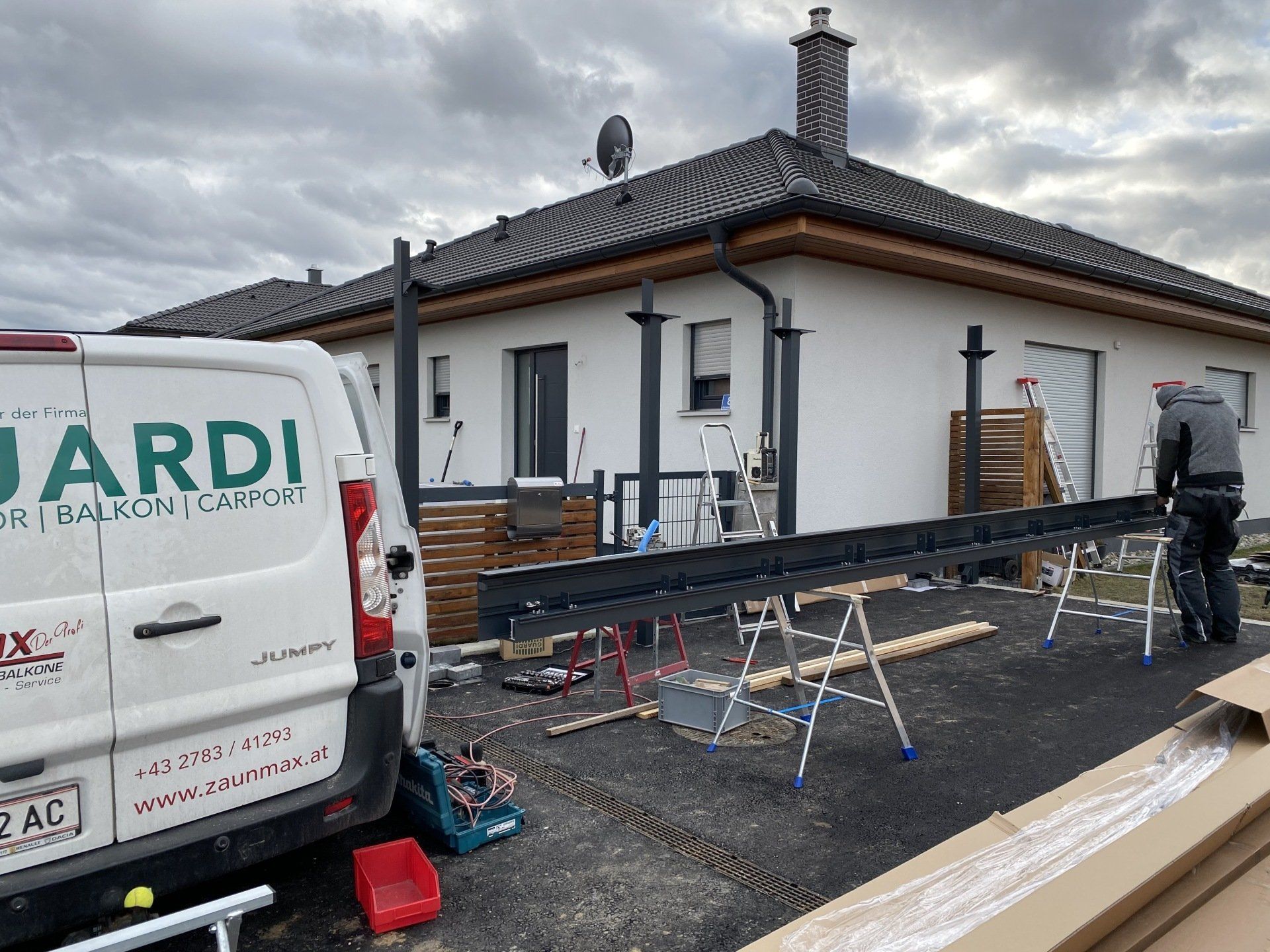 Ein weißer Lieferwagen mit dem Wort „Jardi“ auf der Rückseite steht vor einem Haus.