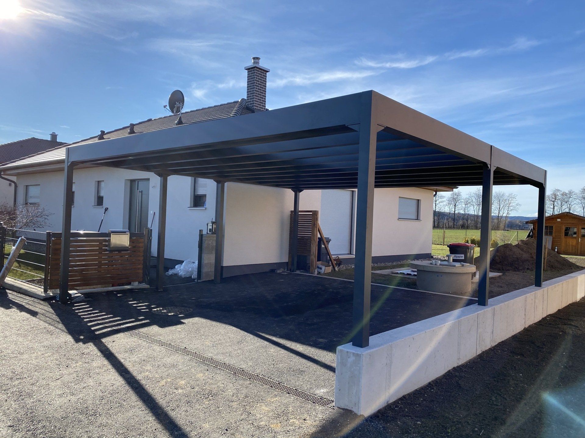 Ein weißes Haus mit einem Carport davor.