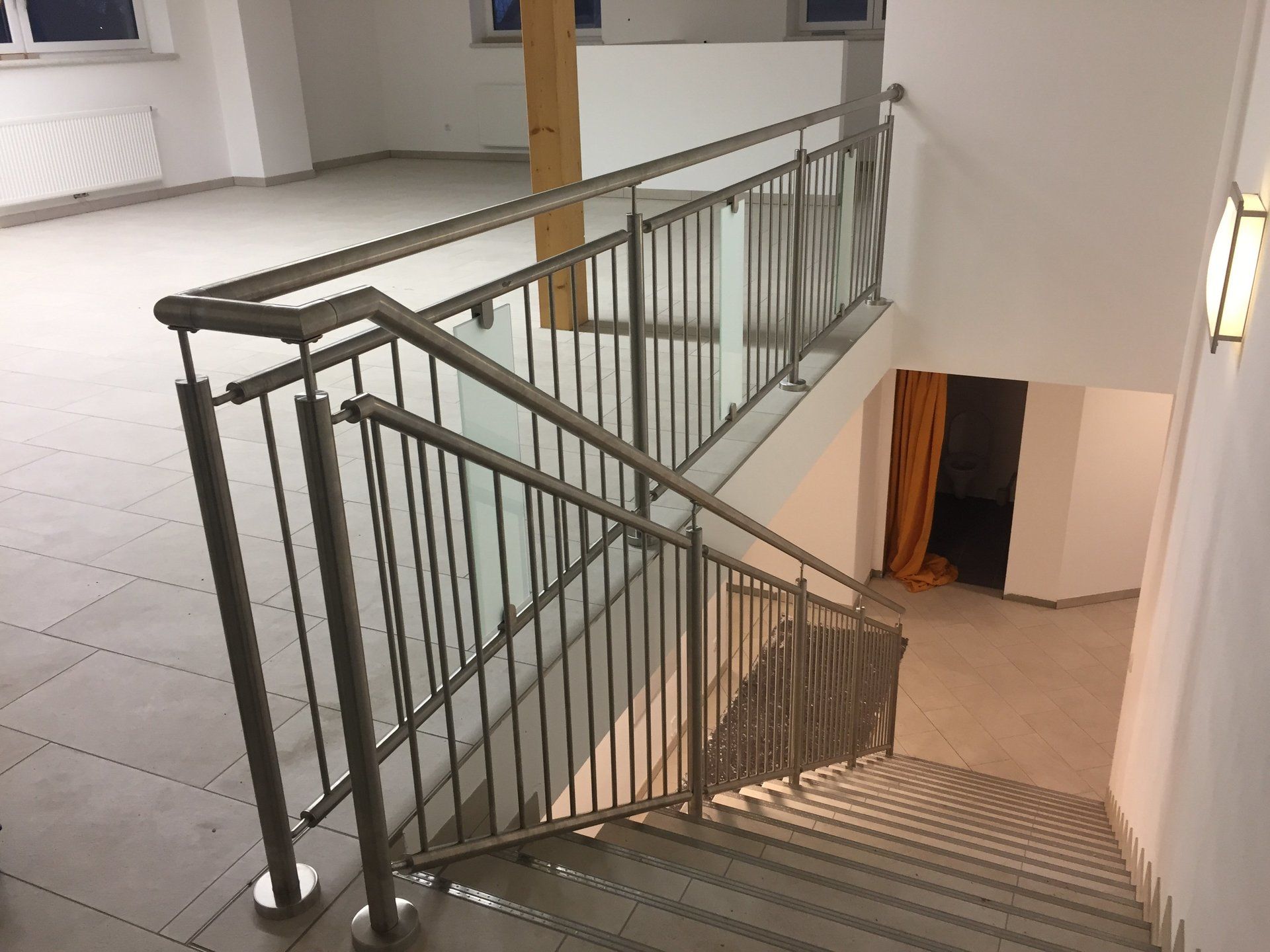Eine Treppe mit einem Metallgeländer und einem Glasgeländer