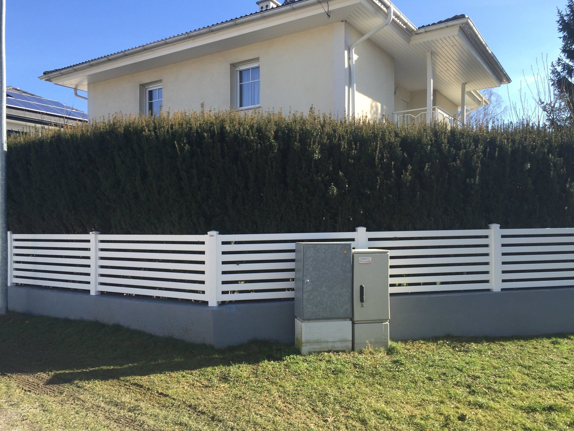Ein Haus mit einem weißen Zaun darum