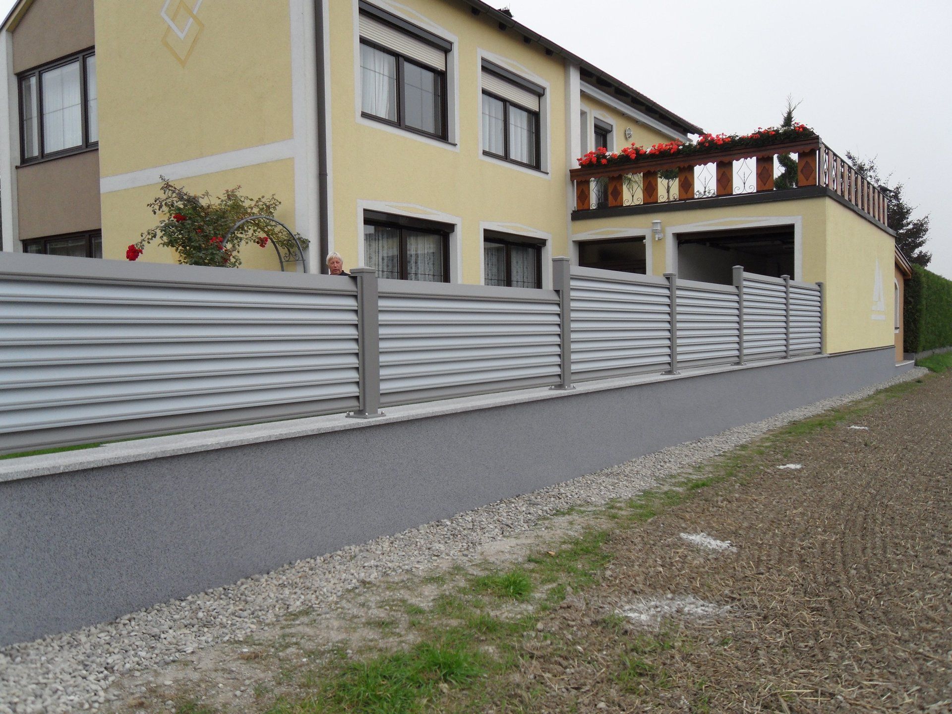Ein Haus mit einem weißen Zaun davor