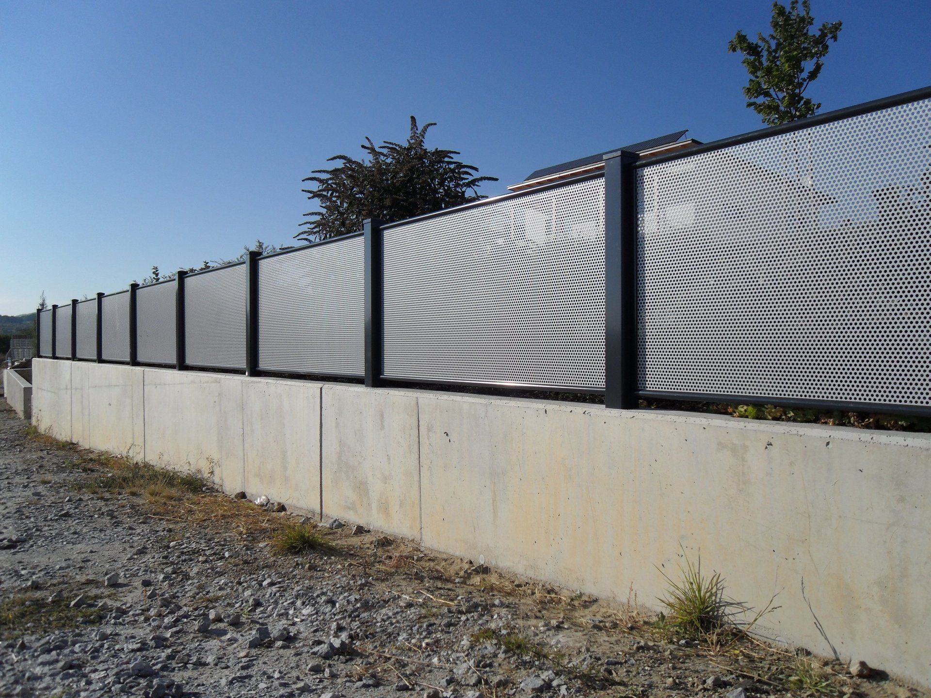 Eine Betonmauer, die von einem Metallzaun umgeben ist