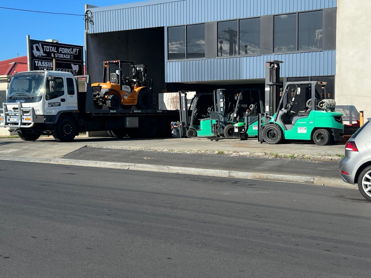 A forklift is sitting on a concrete floor in a warehouse.