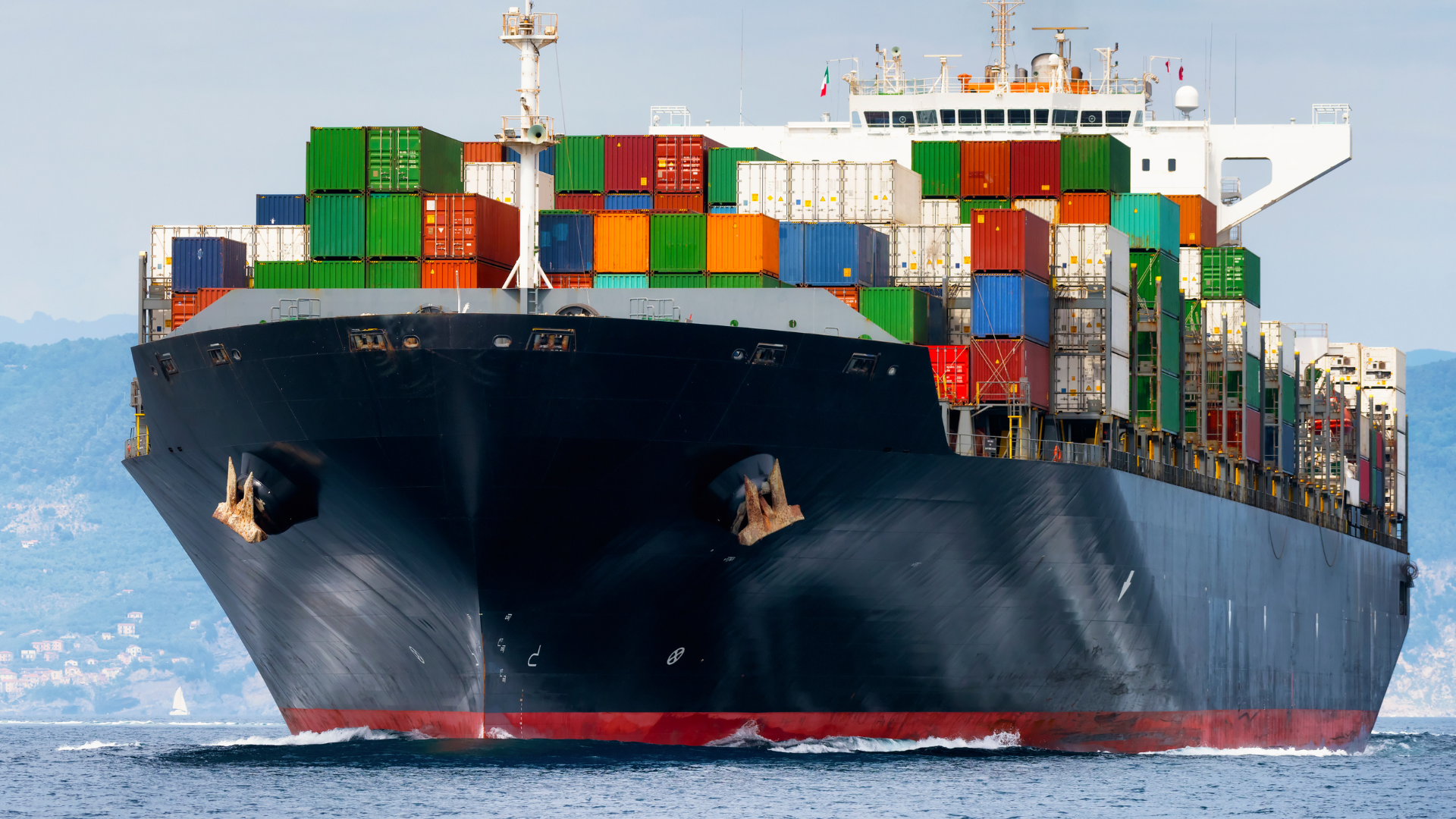 A large container ship is floating on top of a body of water.