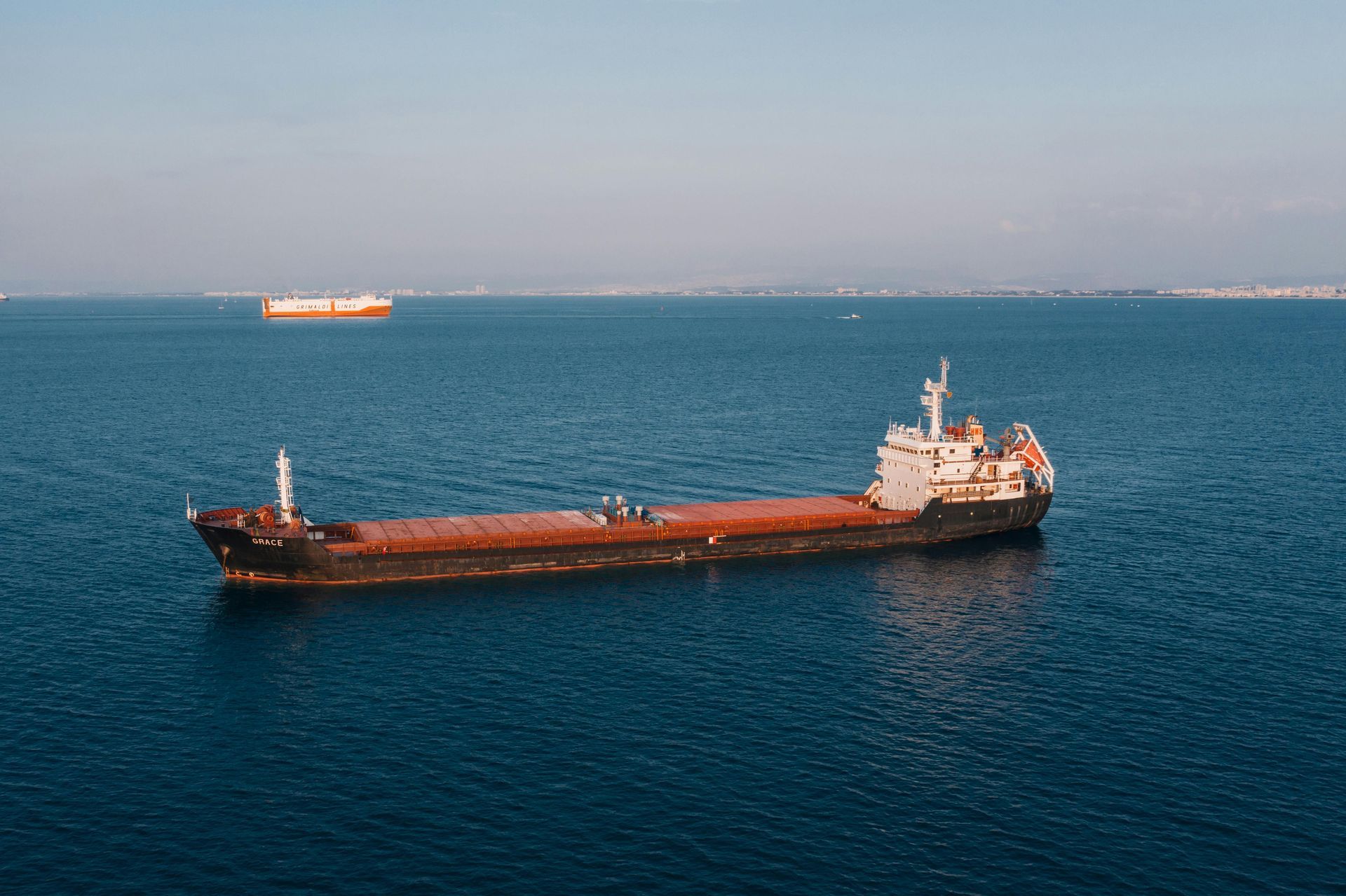 A large cargo ship is floating on top of a large body of water.
