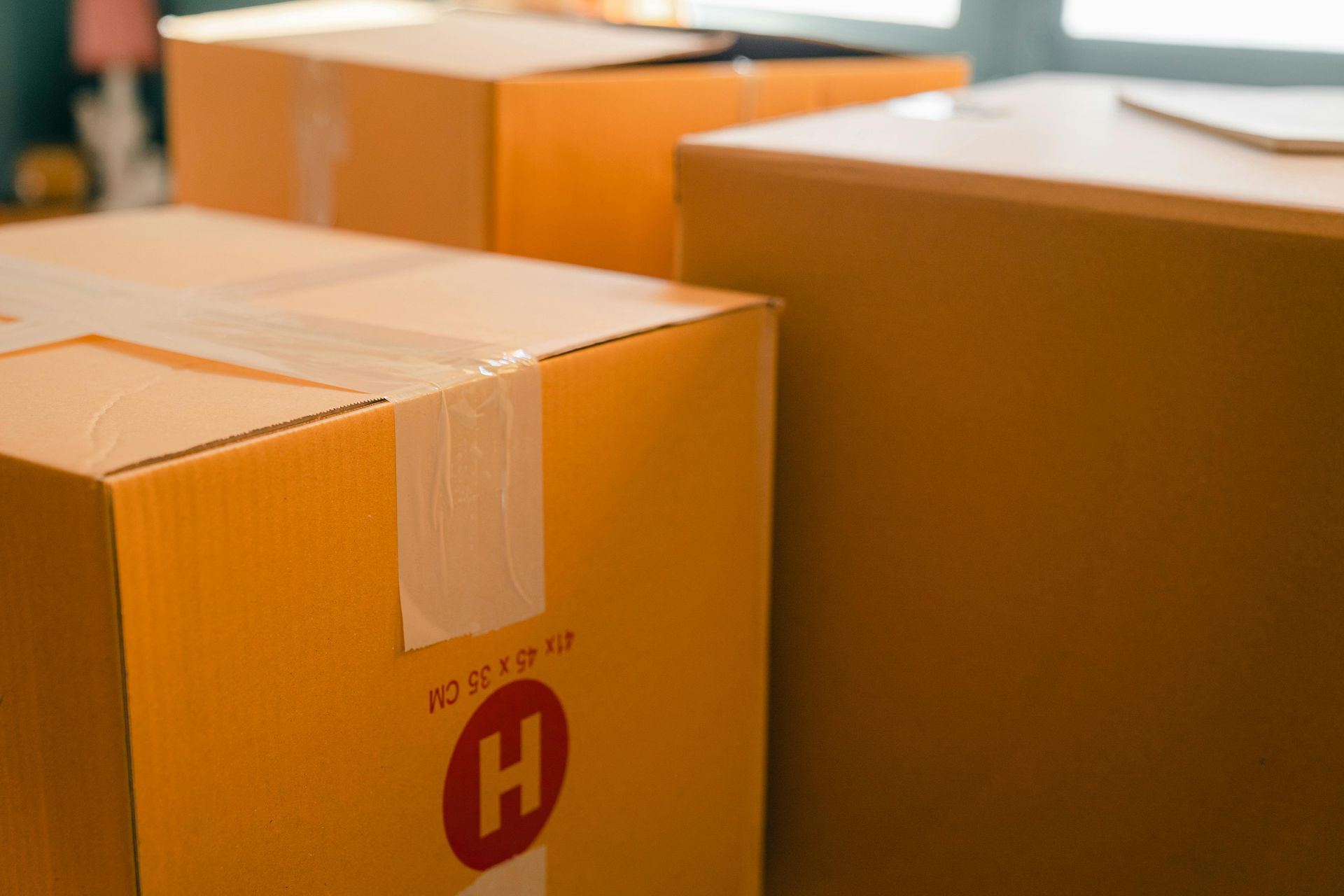 Three cardboard boxes are sitting on top of each other on a table.