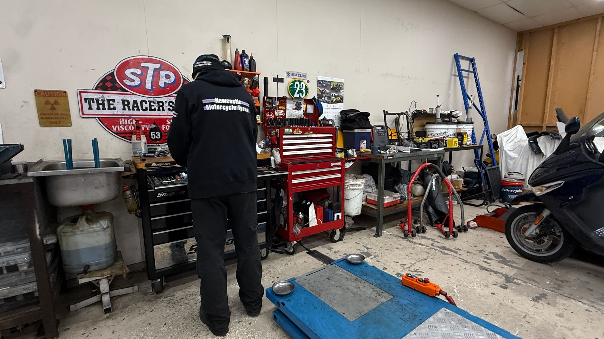 A man is in a garage at work station — Newcastle Motorcycle Tyres in Broadmeadow, NSW