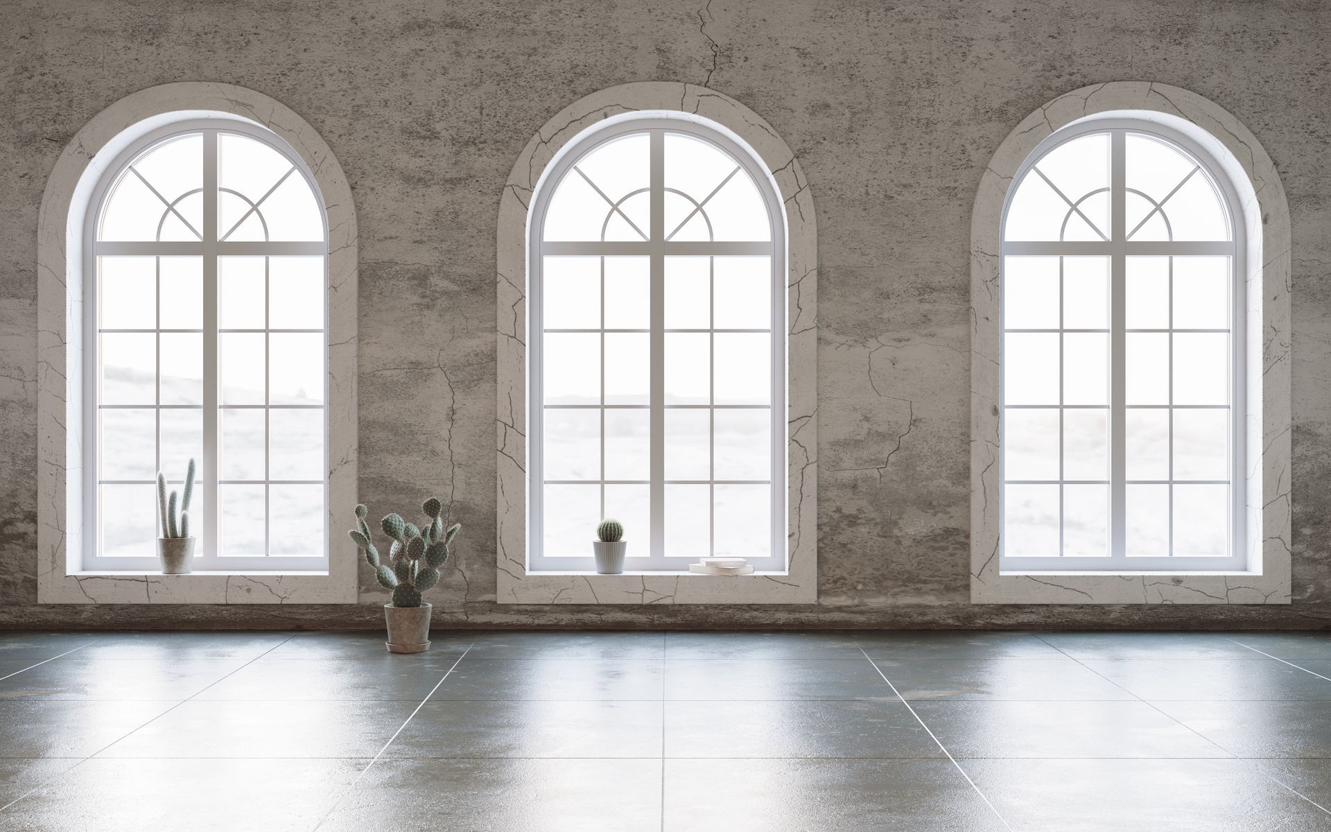 Empty room with three arched windows, gray stone walls, and a small potted plant on the floor