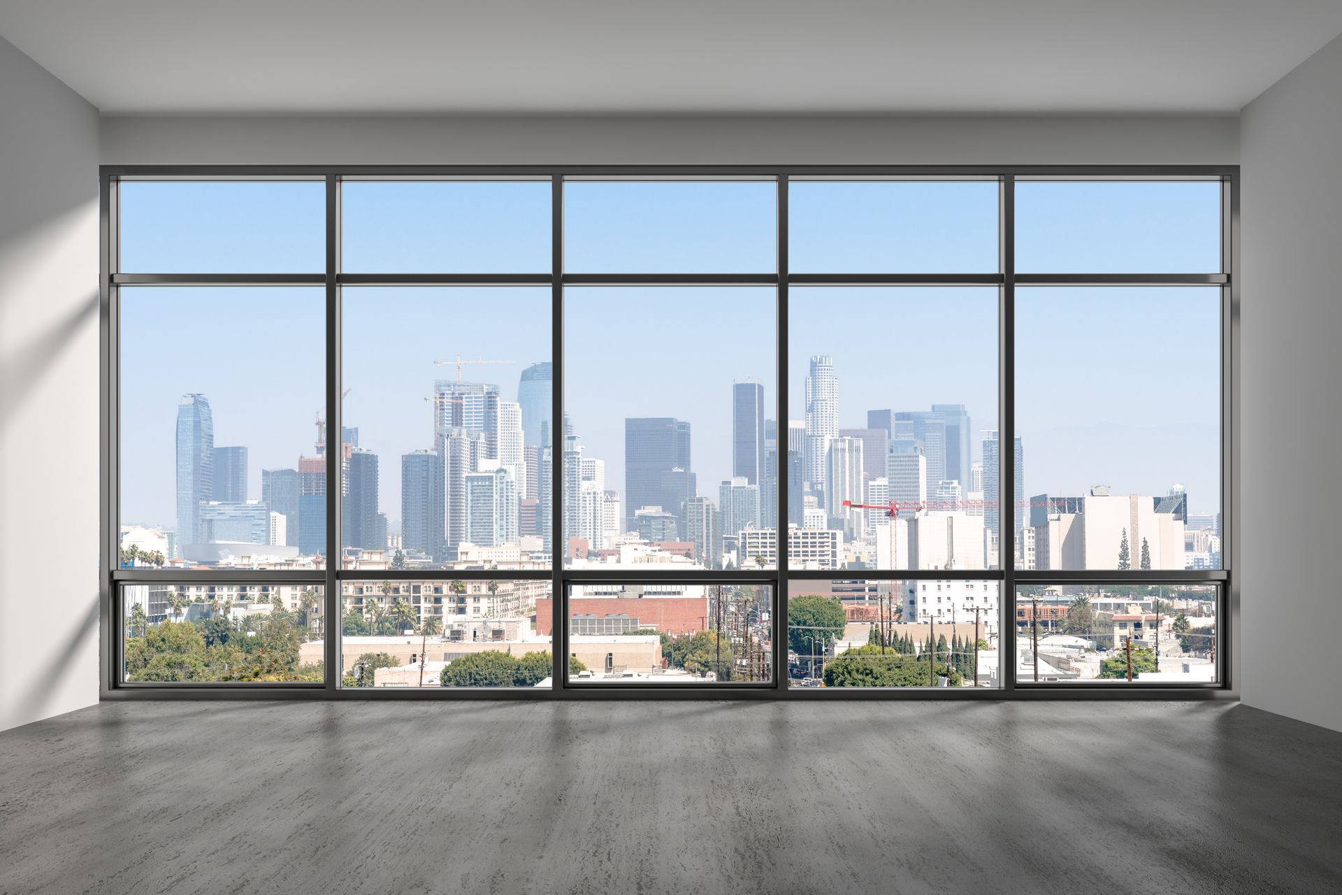 Empty modern room with floor-to-ceiling windows overlooking a city skyline