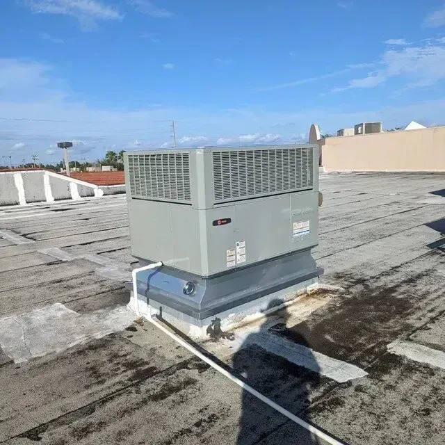 Hvac-Contractor-Bradenton-Gray rooftop HVAC unit on a flat, weathered roof under a blue sky.