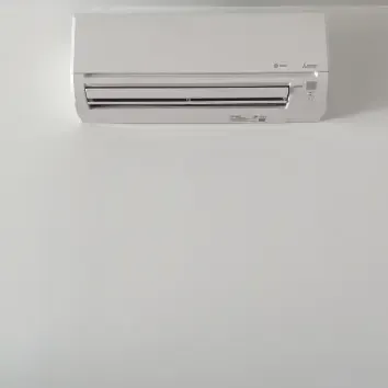 Hvac-Contractor-Bradenton-A white air conditioner is hanging on a white wall.