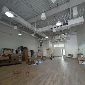 Hvac-Contractor-Bradenton-A large empty room with wooden floors and lots of boxes.
