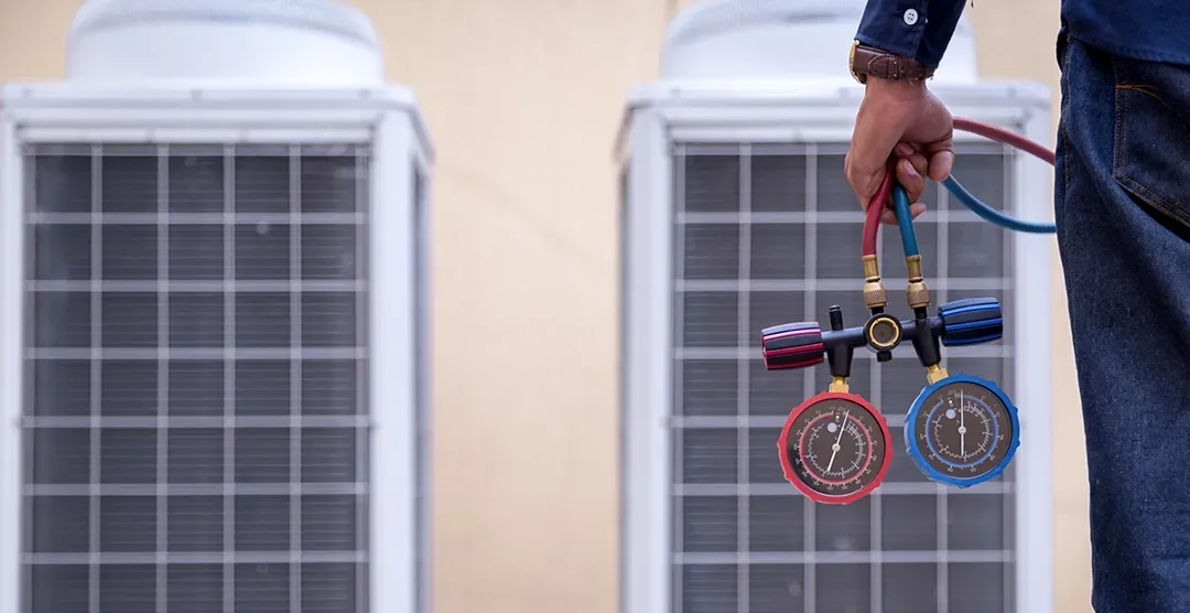 A man is holding a pair of gauges in front of a building.
