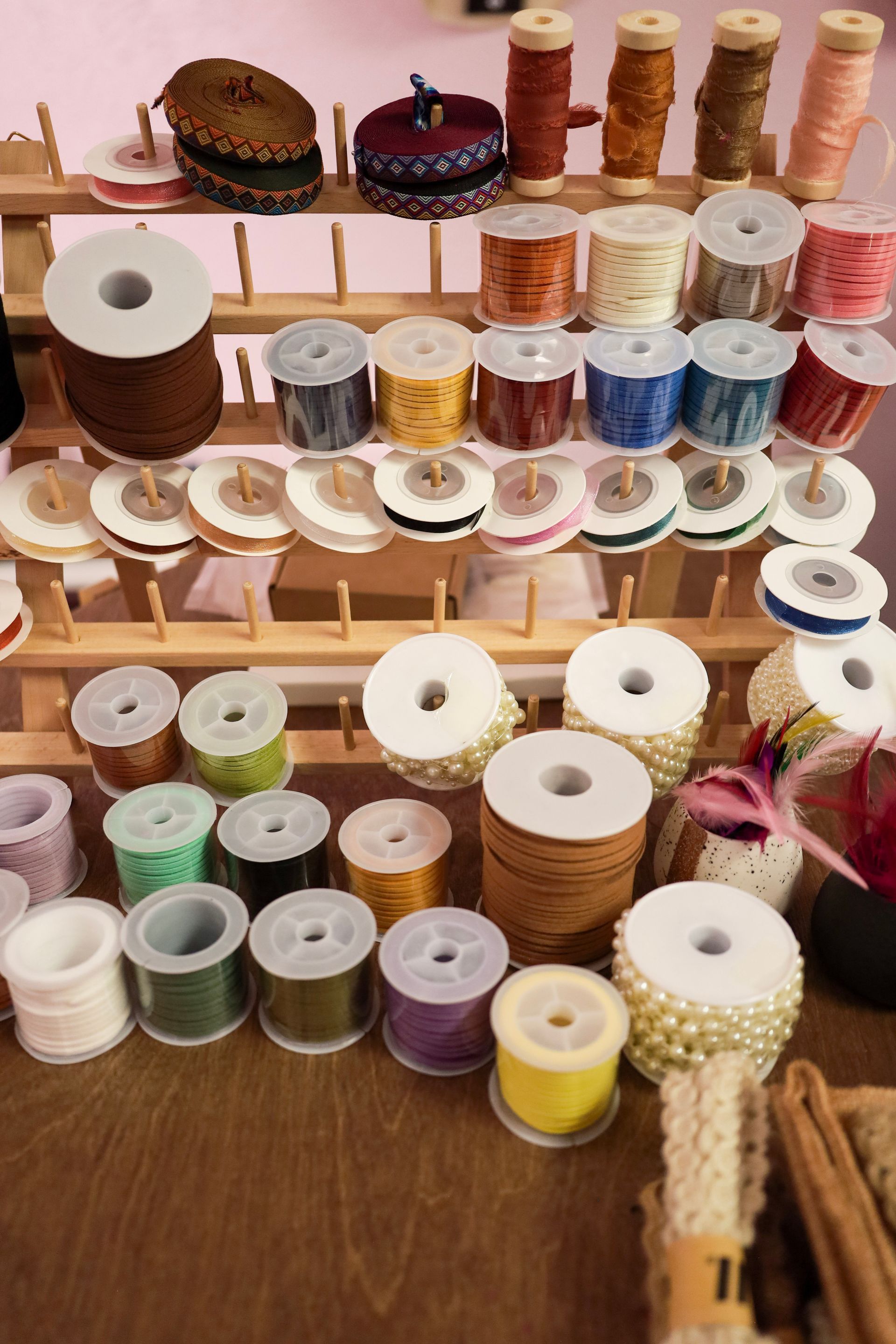 Assorted spools of thread and ribbon displayed on shelves in a craft shop