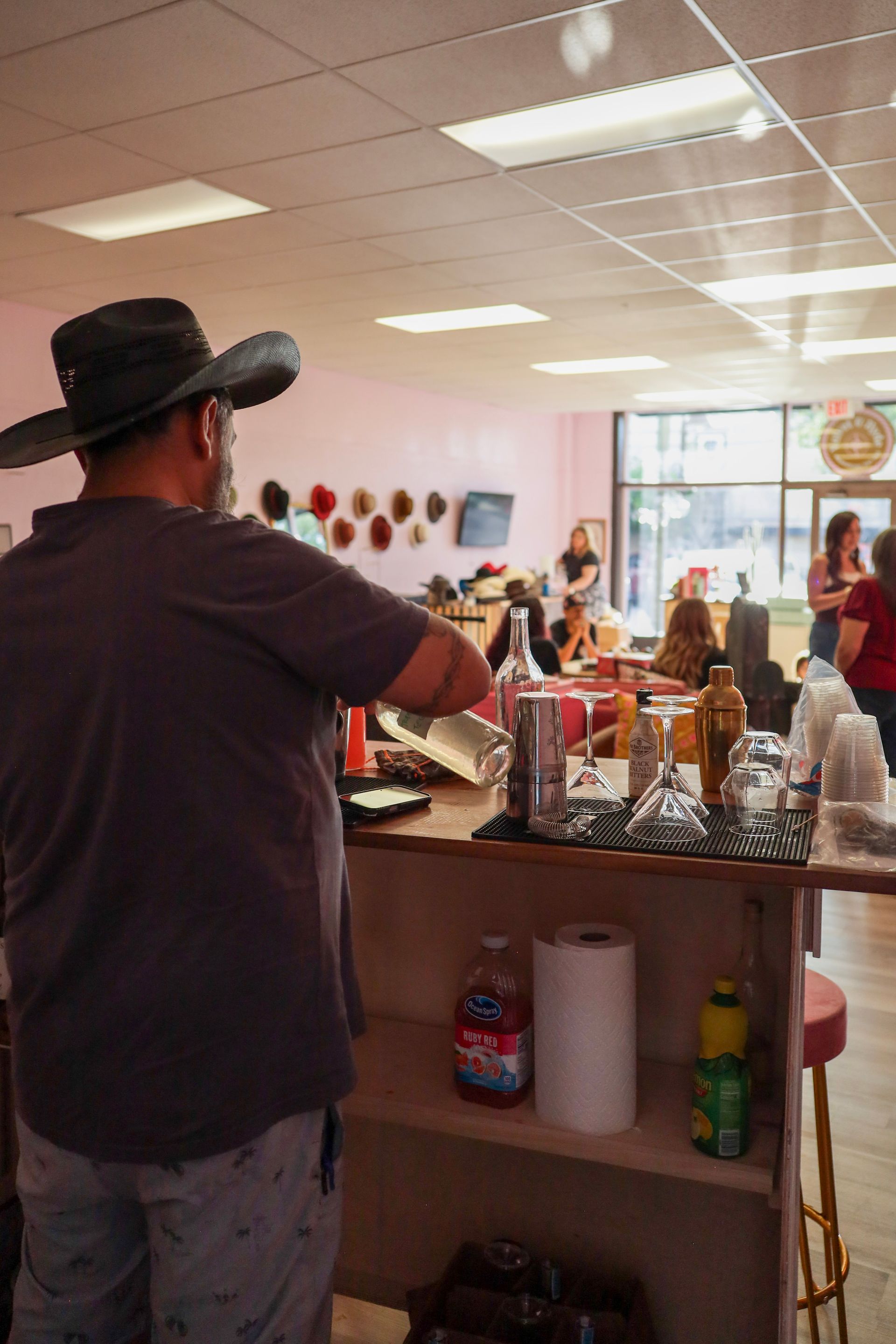 Man playing guitar at the front of a small café with people seated inside