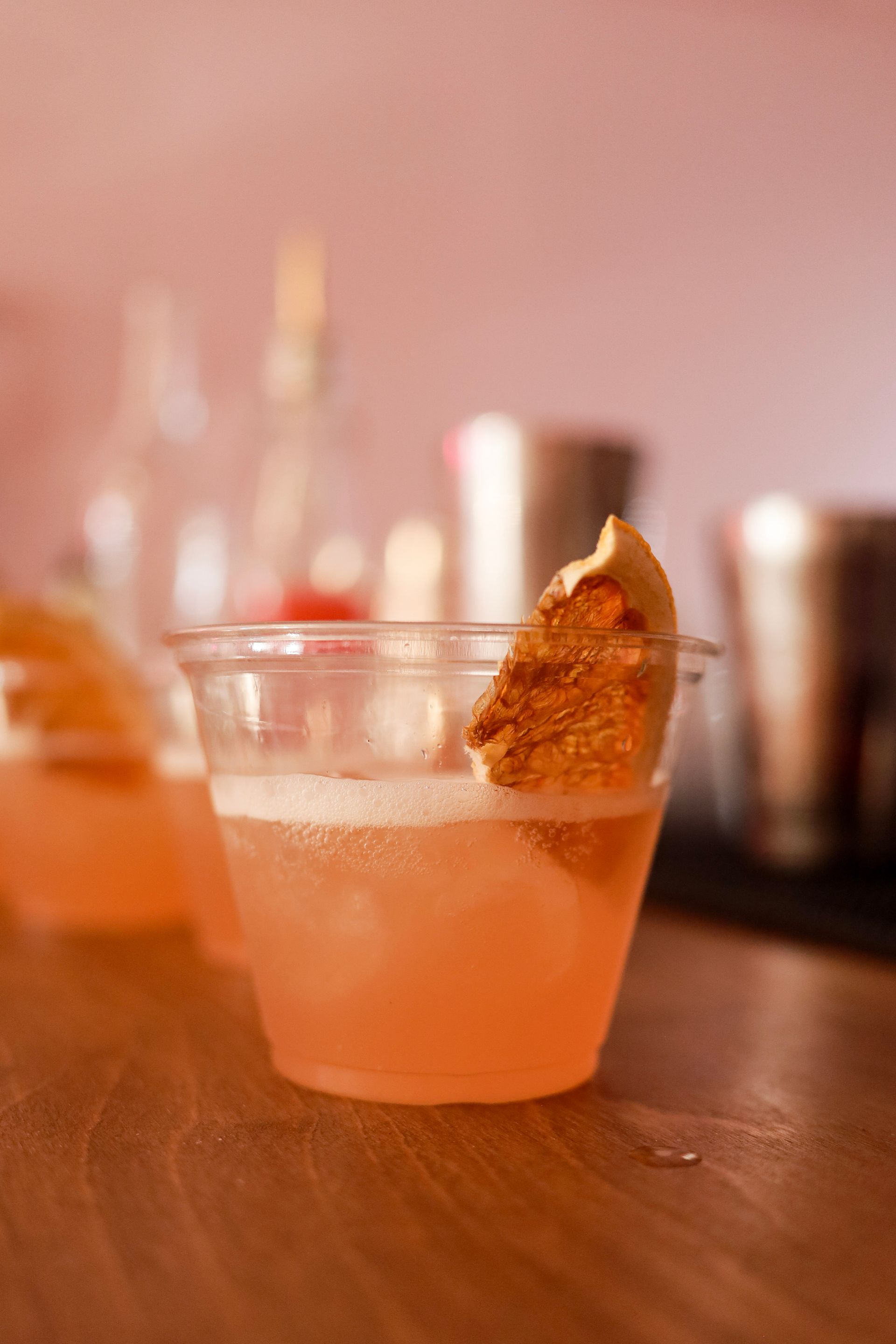 Orange cocktail in a short glass with a sugared rim and citrus garnish on a bar counter