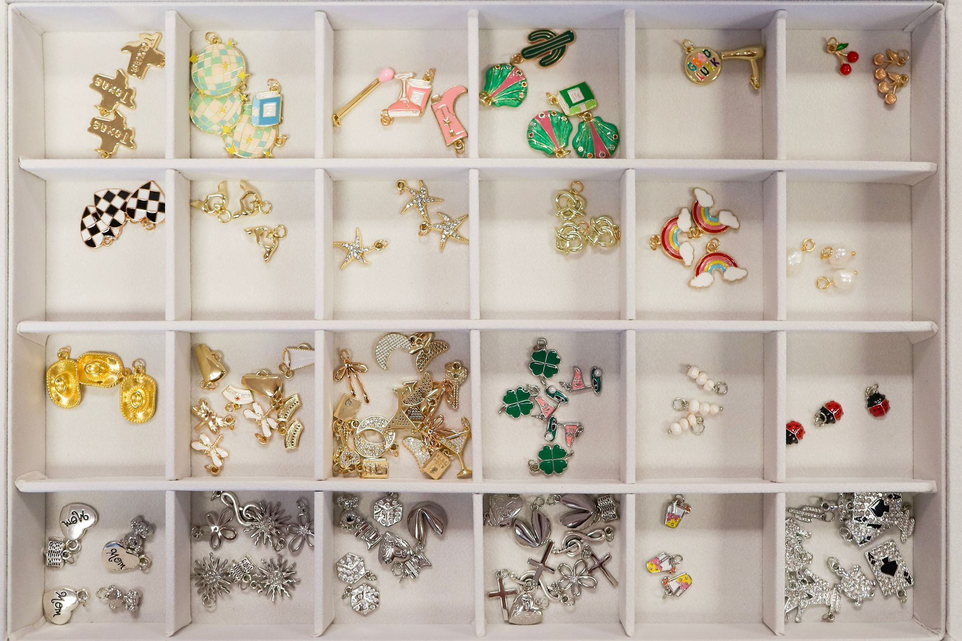 Open jewelry organizer with assorted colorful pins and brooches in separate compartments