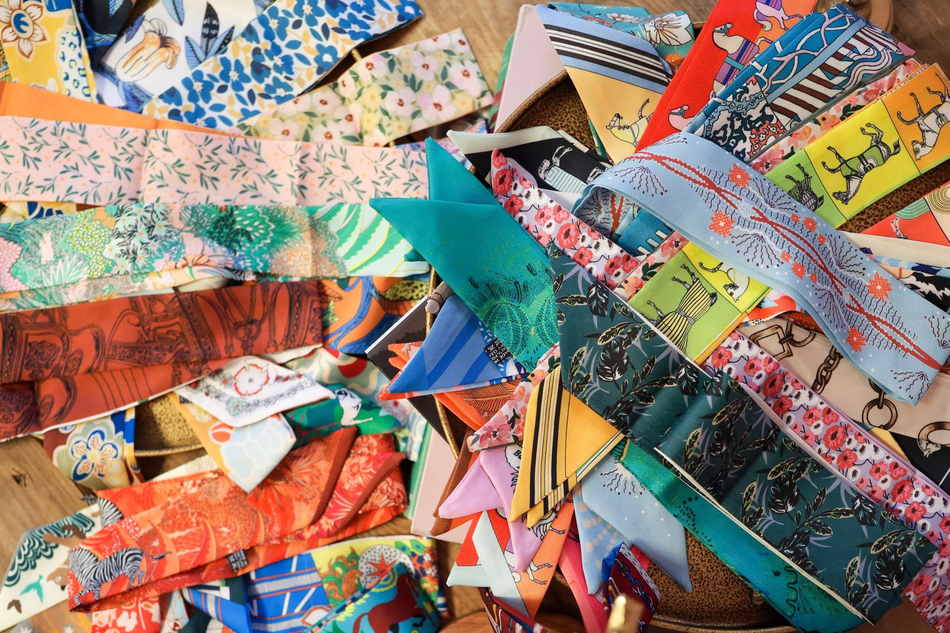 Colorful handmade paper garlands and patterned fabric strips arranged in a layered, vibrant textile collage