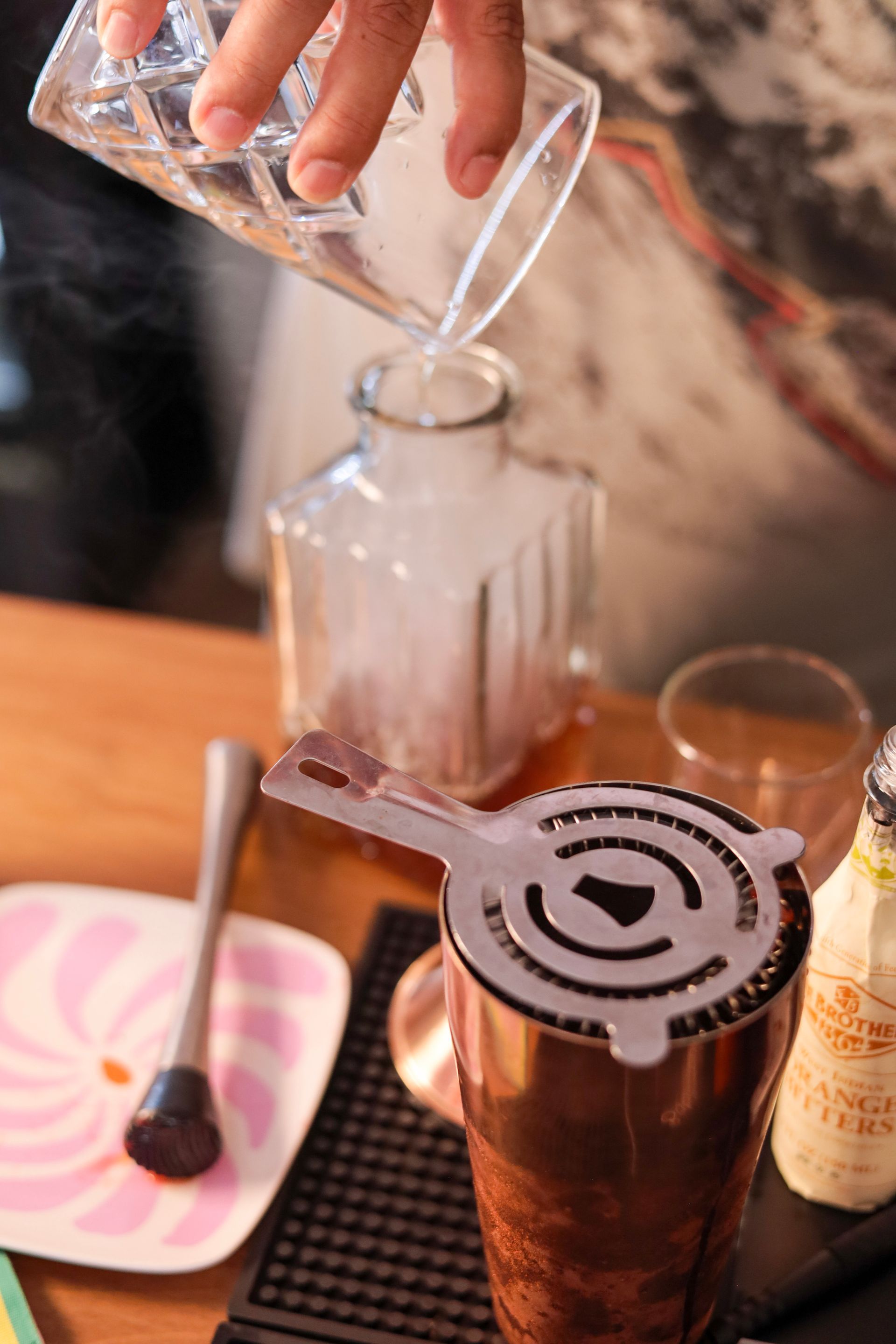 Pouring coffee into a glass dripper over a mug on a wooden table