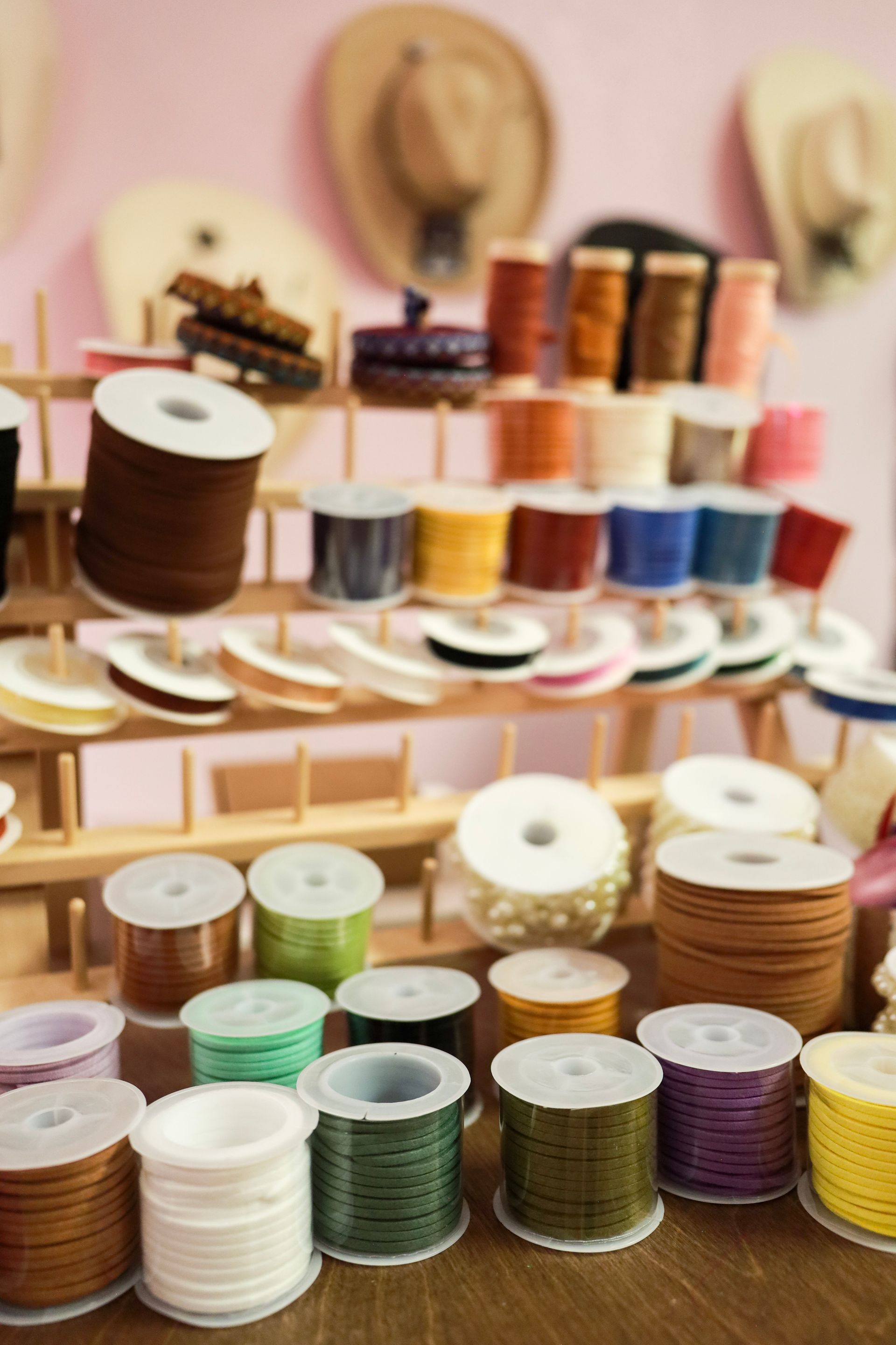 Spools of colorful thread and ribbon arranged on shelves in a craft shop display