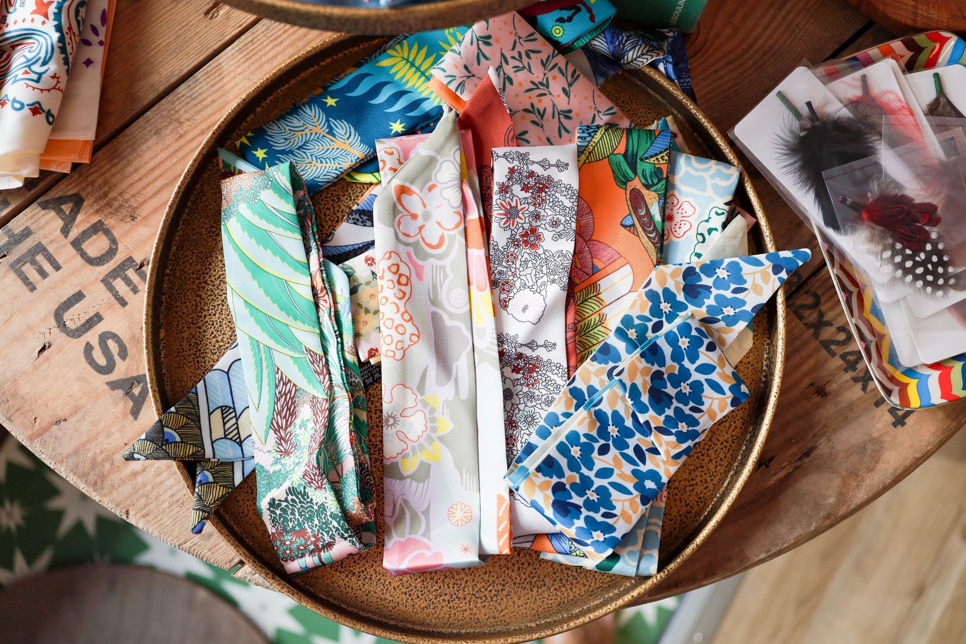 Assorted colorful patterned fabric strips arranged in a round woven basket on a rustic wooden table