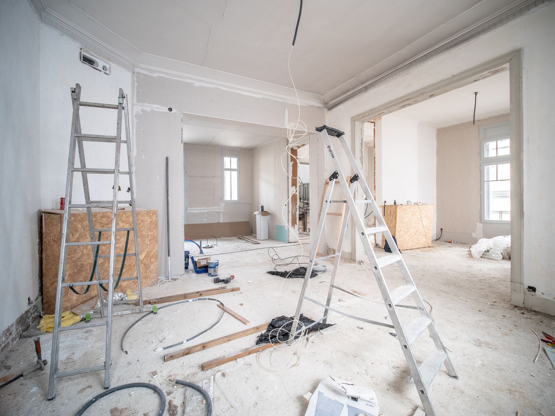 A room is being remodeled with a ladder in the middle of the room.