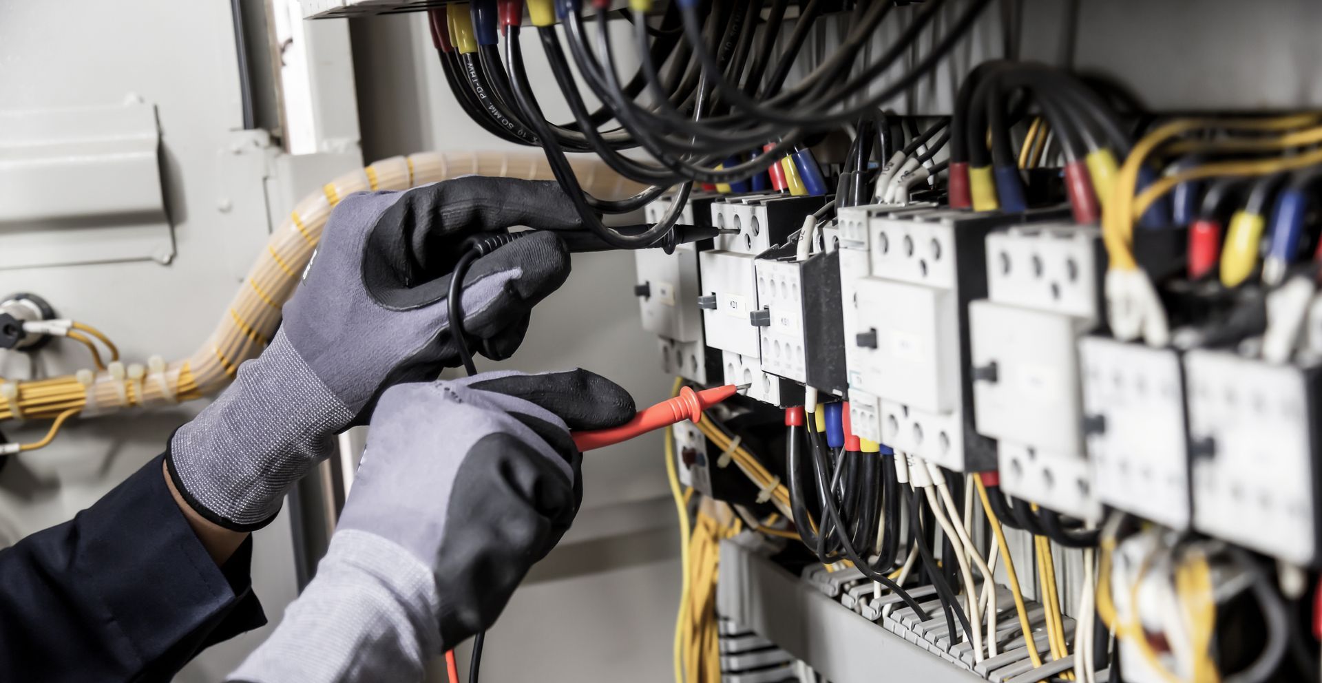 An electrician is working on an electrical panel.