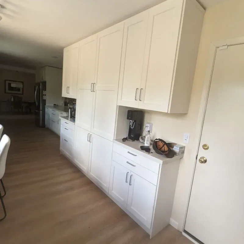 A kitchen with white cabinets and a door